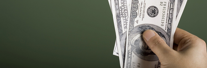 Mão segurando notas de dólares